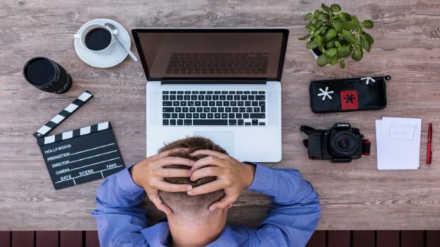 パソコンの前で頭を抱える男性