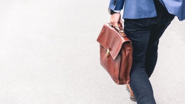 カバンを持って歩くスーツの男性