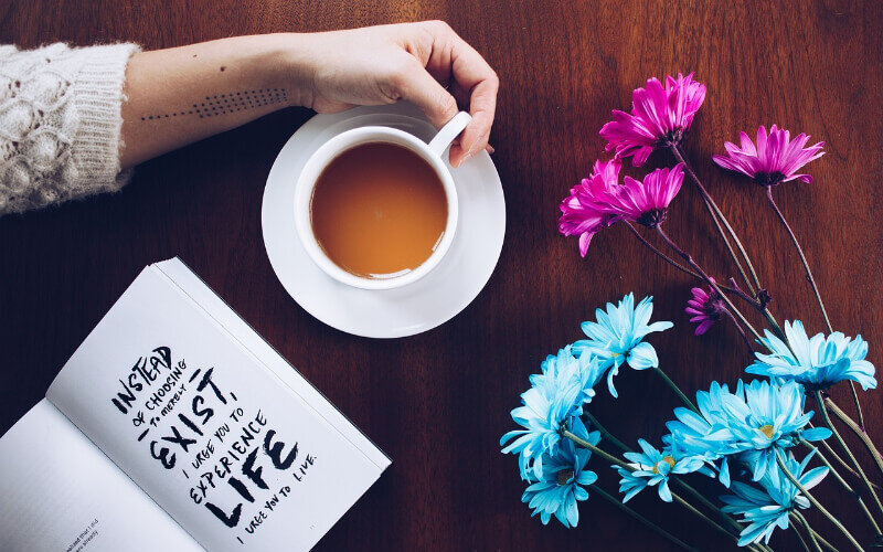 机の上に無造作に置かれた花とコーヒーカップ