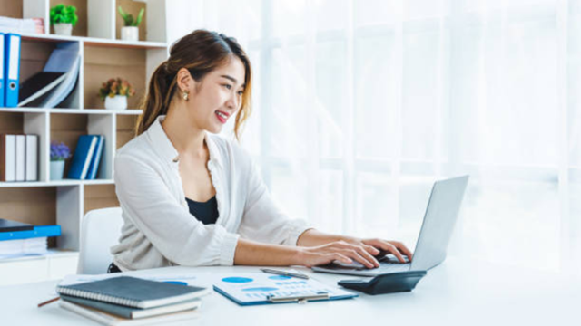 キーボードを打ちながら微笑む女性